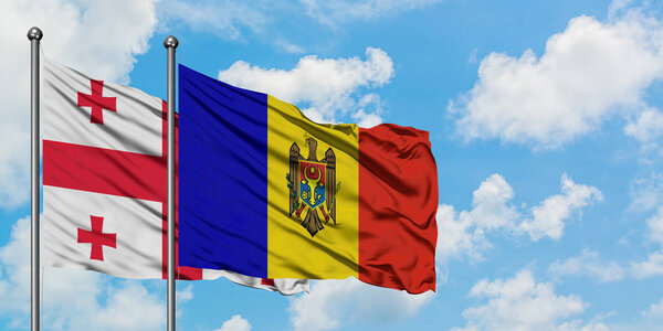 Georgia and Moldova flag waving in the wind against white cloudy blue sky together. Diplomacy concept, international relations.