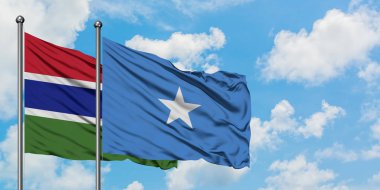 Gambiya ve Somali bayrağı birlikte beyaz bulutlu mavi gökyüzüne karşı rüzgarda sallayarak. Diplomasi kavramı, uluslararası ilişkiler.