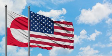 Grönland ve Amerika Birleşik Devletleri bayrağı birlikte beyaz bulutlu mavi gökyüzüne karşı rüzgarda sallayarak. Diplomasi kavramı, uluslararası ilişkiler.