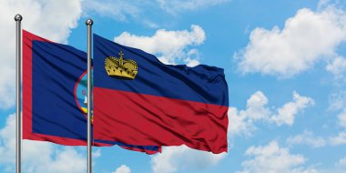 Guam ve Liechtenstein bayrağı birlikte beyaz bulutlu mavi gökyüzüne karşı rüzgarda sallayarak. Diplomasi kavramı, uluslararası ilişkiler.