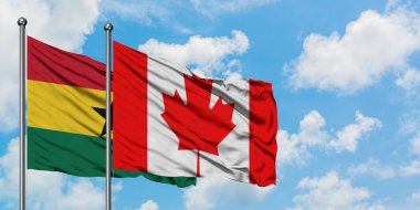 Gana ve Kanada bayrağı birlikte beyaz bulutlu mavi gökyüzüne karşı rüzgarda sallayarak. Diplomasi kavramı, uluslararası ilişkiler.