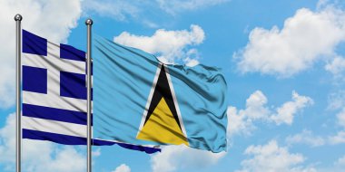 Yunanistan ve Saint Lucia bayrağı birlikte beyaz bulutlu mavi gökyüzüne karşı rüzgarda sallayarak. Diplomasi kavramı, uluslararası ilişkiler.