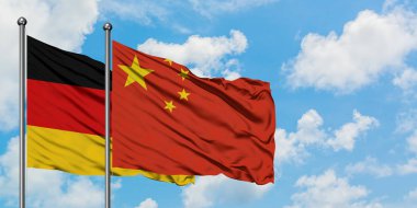 Almanya ve Çin bayrağı birlikte beyaz bulutlu mavi gökyüzüne karşı rüzgarsal sallayarak. Diplomasi kavramı, uluslararası ilişkiler.