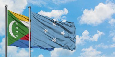 Komorlar ve Mikronezya bayrağı birlikte beyaz bulutlu mavi gökyüzüne karşı rüzgarda sallayarak. Diplomasi kavramı, uluslararası ilişkiler.