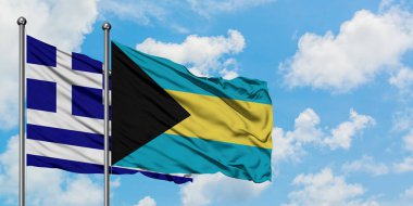 Yunanistan ve Bahamalar bayrağı birlikte beyaz bulutlu mavi gökyüzüne karşı rüzgarda sallayarak. Diplomasi kavramı, uluslararası ilişkiler.