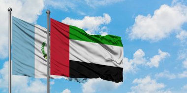 Guatemala ve Birleşik Arap Emirlikleri bayrağı birlikte beyaz bulutlu mavi gökyüzüne karşı rüzgarsal sallayarak. Diplomasi kavramı, uluslararası ilişkiler.