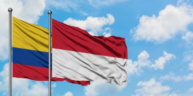 Kolombiya ve Endonezya bayrağı birlikte beyaz bulutlu mavi gökyüzüne karşı rüzgarsal sallayarak. Diplomasi kavramı, uluslararası ilişkiler.