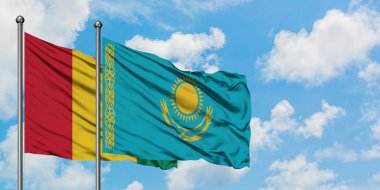 Gine ve Kazakistan bayrağı birlikte beyaz bulutlu mavi gökyüzüne karşı rüzgarsal sallayarak. Diplomasi kavramı, uluslararası ilişkiler.