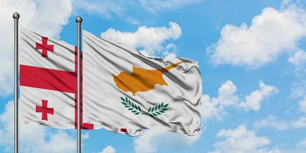 Georgia and Cyprus flag waving in the wind against white cloudy blue sky together. Diplomacy concept, international relations. — Stock Photo, Image