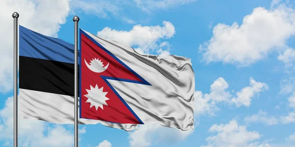 Estonya ve Nepal bayrağı birlikte beyaz bulutlu mavi gökyüzüne karşı rüzgarda sallayarak. Diplomasi kavramı, uluslararası ilişkiler. — Stok fotoğraf