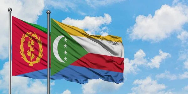 Bandera de Eritrea y Comoras ondeando en el viento contra el cielo azul nublado blanco juntos. Concepto diplomático, relaciones internacionales . — Foto de Stock