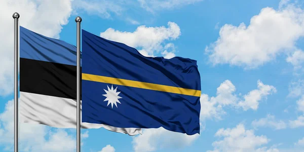 เอสโตเนียและนาอูรุโบกธงในลมกับท้องฟ้าสีขาวเมฆสีฟ้าร่วมกัน แนวคิดทางการทูต ความสัมพันธ์ระหว่างประเทศ . — ภาพถ่ายสต็อก