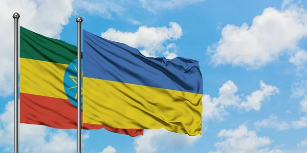 Etiopía y Ucrania bandera ondeando en el viento contra blanco cielo azul nublado juntos. Concepto diplomático, relaciones internacionales . — Foto de Stock