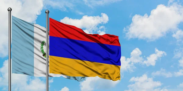Bandera de Guatemala y Armenia ondeando en el viento contra el cielo azul nublado blanco juntos. Concepto diplomático, relaciones internacionales . — Foto de Stock