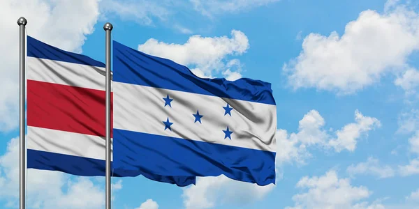 Коста-Ріка і Гондурас прапор махав на вітрі від білого хмарного синього неба разом. Концепція дипломатії, міжнародні відносини. — стокове фото