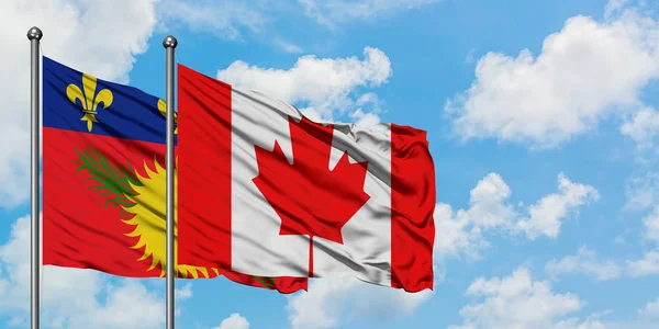 Guadalupe y la bandera de Canadá ondeando en el viento contra el cielo azul nublado blanco juntos. Concepto diplomático, relaciones internacionales . — Foto de Stock