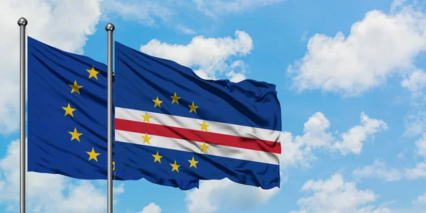 União Europeia e bandeira de Cabo Verde agitando no vento contra o céu azul nublado branco juntos. Conceito de diplomacia, relações internacionais . — Fotografia de Stock