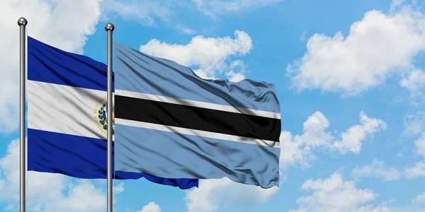 El salvador und Botswana-Flagge wehen gemeinsam im Wind gegen den wolkenverhangenen blauen Himmel. Diplomatie-Konzept, internationale Beziehungen. — Stockfoto