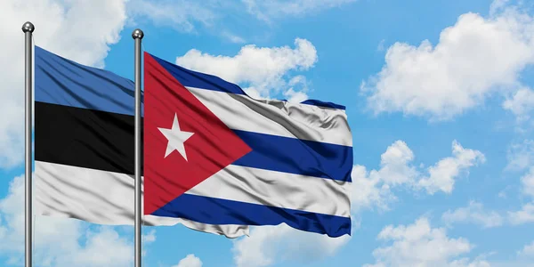 Estland och Kuba flagga vifta i vinden mot vit grumlig blå himmel tillsammans. Diplomatisk koncept, internationella relationer. — Stockfoto