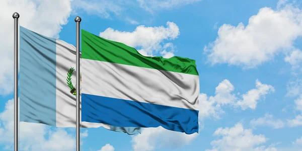Guatemala ve Sierra Leone bayrağı birlikte beyaz bulutlu mavi gökyüzüne karşı rüzgarda sallayarak. Diplomasi kavramı, uluslararası ilişkiler. — Stok fotoğraf