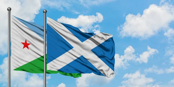 Djibuti e a bandeira da Escócia agitando no vento contra o céu azul nublado branco juntos. Conceito de diplomacia, relações internacionais . — Fotografia de Stock