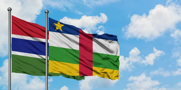 Bandera de Gambia y República Centroafricana ondeando en el viento contra el cielo azul nublado blanco juntos. Concepto diplomático, relaciones internacionales . — Foto de Stock