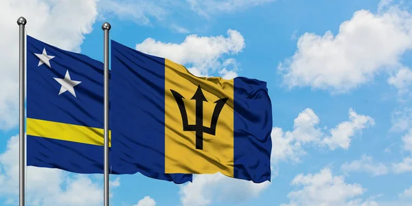 Bandera de Curazao y Barbados ondeando en el viento contra el cielo azul nublado blanco juntos. Concepto diplomático, relaciones internacionales . — Foto de Stock