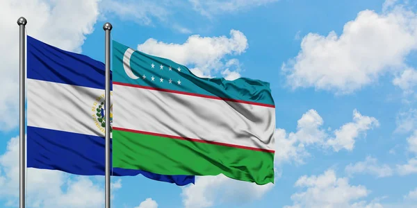 Η σημαία του Ελ Σαλβαδόρ και του Ουζμπεκιστάν κουνώντας τον άνεμο ενάντια στον λευκό θολό γαλάζιο ουρανό μαζί. Φιλοσοφία της διπλωματίας, διεθνείς σχέσεις. — Φωτογραφία Αρχείου