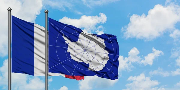 Bandera de Francia y la Antártida ondeando en el viento contra el cielo azul nublado blanco juntos. Concepto diplomático, relaciones internacionales . — Foto de Stock