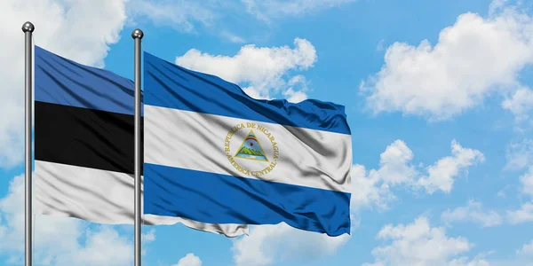 Естонія і Нікарагуа прапор розмахуючи в вітру проти білого хмарного синього неба разом. Концепція дипломатії, міжнародні відносини. — стокове фото
