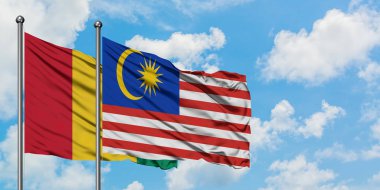 Gine ve Malezya bayrağı birlikte beyaz bulutlu mavi gökyüzüne karşı rüzgarda sallayarak. Diplomasi kavramı, uluslararası ilişkiler.