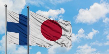 Finlandiya ve Japonya bayrağı birlikte beyaz bulutlu mavi gökyüzüne karşı rüzgarsal sallayarak. Diplomasi kavramı, uluslararası ilişkiler.
