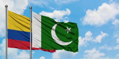 Kolombiya ve Pakistan bayrağı birlikte beyaz bulutlu mavi gökyüzüne karşı rüzgarda sallayarak. Diplomasi kavramı, uluslararası ilişkiler.