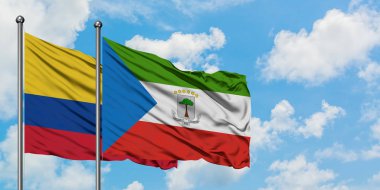 Kolombiya ve Ekvator Ginesi bayrağı birlikte beyaz bulutlu mavi gökyüzüne karşı rüzgarda sallayarak. Diplomasi kavramı, uluslararası ilişkiler.