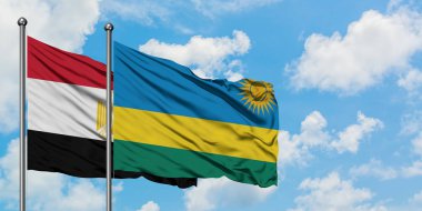 Mısır ve Ruanda bayrağı birlikte beyaz bulutlu mavi gökyüzüne karşı rüzgarda sallayarak. Diplomasi kavramı, uluslararası ilişkiler.