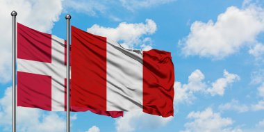 Danimarka ve Peru bayrağı birlikte beyaz bulutlu mavi gökyüzüne karşı rüzgarda sallayarak. Diplomasi kavramı, uluslararası ilişkiler.