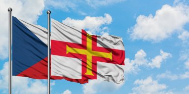 Çek Cumhuriyeti ve Guernsey bayrağı birlikte beyaz bulutlu mavi gökyüzüne karşı rüzgarda sallayarak. Diplomasi kavramı, uluslararası ilişkiler.