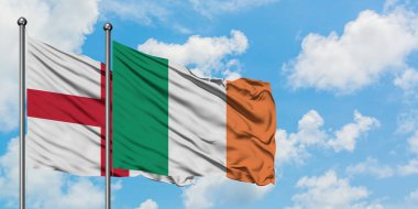 İngiltere ve İrlanda bayrağı birlikte beyaz bulutlu mavi gökyüzüne karşı rüzgarda sallayarak. Diplomasi kavramı, uluslararası ilişkiler.