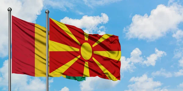 Guinee en Macedonië vlag zwaaien in de wind tegen witte bewolkte blauwe hemel samen. Diplomatie concept, internationale betrekkingen. — Stockfoto