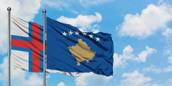 페로 제도와 코소보 깃발이 하얀 흐린 푸른 하늘을 배경으로 바람에 흔들리고 있습니다. 외교 개념, 국제 관계. — 스톡 사진