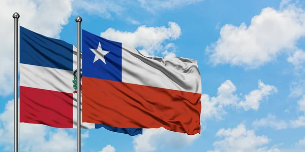 Dominikánská republika a Chile vlají ve větru proti bíle zatažené modré obloze. Diplomacie, mezinárodní vztahy. — Stock fotografie