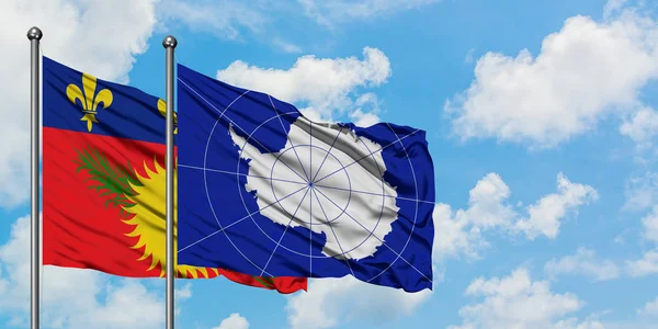 Guadalupe y la bandera de la Antártida ondeando en el viento contra el cielo azul nublado blanco juntos. Concepto diplomático, relaciones internacionales . — Foto de Stock