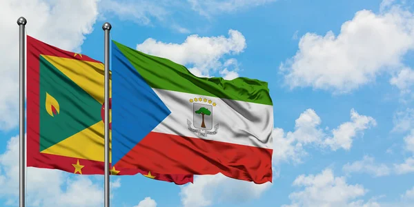 Bandera de Granada y Guinea Ecuatorial ondeando en el viento contra el cielo azul nublado blanco juntos. Concepto diplomático, relaciones internacionales . — Foto de Stock