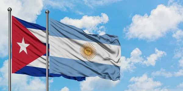 Cuba e a bandeira da Argentina agitando no vento contra o céu azul nublado branco juntos. Conceito de diplomacia, relações internacionais . — Fotografia de Stock