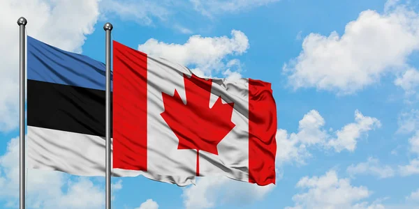 Bandera de Estonia y Canadá ondeando en el viento contra el cielo azul nublado blanco juntos. Concepto diplomático, relaciones internacionales . — Foto de Stock