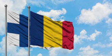 Finlandiya ve Çad bayrağı birlikte beyaz bulutlu mavi gökyüzüne karşı rüzgarda sallayarak. Diplomasi kavramı, uluslararası ilişkiler.