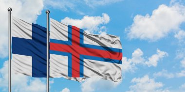 Finlandiya ve Faroe Adaları bayrağı birlikte beyaz bulutlu mavi gökyüzüne karşı rüzgarsal sallayarak. Diplomasi kavramı, uluslararası ilişkiler.