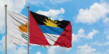 Kıbrıs ve Antigua ve Barbuda bayrağı birlikte beyaz bulutlu mavi gökyüzüne karşı rüzgarda sallayarak. Diplomasi kavramı, uluslararası ilişkiler.