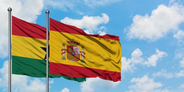 Gana ve İspanya bayrağı birlikte beyaz bulutlu mavi gökyüzüne karşı rüzgarda sallayarak. Diplomasi kavramı, uluslararası ilişkiler.