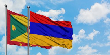 Grenada ve Ermenistan bayrağı birlikte beyaz bulutlu mavi gökyüzüne karşı rüzgarsal sallayarak. Diplomasi kavramı, uluslararası ilişkiler.